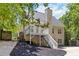 Backyard view featuring a deck with stairs and a well-maintained exterior surrounded by trees at 1620 Concord Meadows Dr, Smyrna, GA 30082