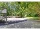 Expansive backyard area with a large concrete slab, grassy area and bordered by mature trees and foliage at 1620 Concord Meadows Dr, Smyrna, GA 30082