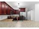 Well-lit kitchen featuring stainless steel appliances, granite countertops, and rich wood cabinetry at 1620 Concord Meadows Dr, Smyrna, GA 30082