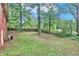 This backyard features a large grassy area and large trees, giving it a shaded appearance at 5868 Ash St, Forest Park, GA 30297