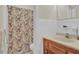 This bathroom features a floral shower curtain and white tiling to give a clean appearance at 5868 Ash St, Forest Park, GA 30297
