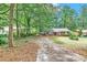 This exterior shows a brick home with a covered parking area and a long driveway at 5868 Ash St, Forest Park, GA 30297