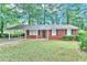 Cozy brick home with covered carport and lush front lawn at 5868 Ash St, Forest Park, GA 30297