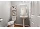 Elegant powder room featuring a pedestal sink, toilet, and modern fixtures at 2015 Liberty Nw Ct, Atlanta, GA 30318
