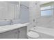 Well-lit bathroom featuring marble tile, grey vanity, shower and bathtub at 2496 Shiloh Dr, Decatur, GA 30034