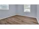 Bedroom featuring wood-look flooring, two windows, and neutral paint at 2496 Shiloh Dr, Decatur, GA 30034