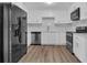 Modern kitchen featuring stainless steel appliances, marble backsplash, white cabinetry and wood flooring at 2496 Shiloh Dr, Decatur, GA 30034