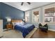 Cozy bedroom featuring hardwood floors, blue accent wall, and natural light from the three windows at 746 N Highland Ne Ave # 7, Atlanta, GA 30306