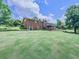 Brick home featuring a deck and a spacious, well-maintained backyard perfect for outdoor entertaining at 104 Cochran Ridge Rd, Dallas, GA 30157