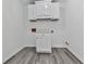 Cozy laundry room featuring white cabinets, utility sink, and gray wood-look flooring at 104 Cochran Ridge Rd, Dallas, GA 30157