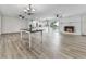 Open-concept living room with a fireplace, dining area, and gray wood-look flooring at 104 Cochran Ridge Rd, Dallas, GA 30157