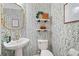 Stylish powder room with a pedestal sink, a gilded mirror, and floral wallpaper at 501 White Oak Path, Canton, GA 30115