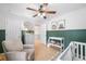 Bedroom with board and batten accent wall, crib, and a light gray chair at 501 White Oak Path, Canton, GA 30115