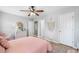 Bedroom with light wood floors, ceiling fan, and a door to an ensuite at 501 White Oak Path, Canton, GA 30115