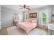 Bright bedroom with a white metal bed frame, wood ceiling fan, and pink bedding at 501 White Oak Path, Canton, GA 30115