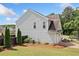 Side view of a light gray home featuring a two-car garage, manicured lawn, and privacy fence at 501 White Oak Path, Canton, GA 30115