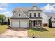 Charming two-story home featuring a two-car garage, covered porch with rocking chairs, and manicured lawn at 501 White Oak Path, Canton, GA 30115