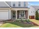 Close-up of the front porch with stone accents, white rocking chairs, and decorative floral arrangements at 501 White Oak Path, Canton, GA 30115