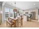 Eat-in kitchen boasts white cabinets, stainless steel appliances, pendant lighting, and light hardwood floors at 501 White Oak Path, Canton, GA 30115