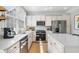 Bright kitchen features white cabinets, stainless steel appliances, a kitchen island and hardwood floors at 501 White Oak Path, Canton, GA 30115