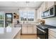 Well-lit kitchen featuring stainless steel appliances, white countertops and a door to the patio at 501 White Oak Path, Canton, GA 30115