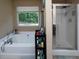 Bright bathroom features a soaking tub and a separate glass-enclosed shower at 5976 Rosie Se Ln, Mableton, GA 30126