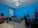 Bedroom with blue walls featuring guitars, a ceiling fan, carpeted floors, and natural light from the window at 5976 Rosie Se Ln, Mableton, GA 30126