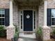 Inviting front porch with brick columns, decorative plants, and a 'Welcome Home' wreath at 5976 Rosie Se Ln, Mableton, GA 30126