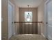 Upstairs hallway features a decorative light fixture, railing, and neutral carpet at 5976 Rosie Se Ln, Mableton, GA 30126