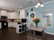 Well-lit kitchen with white cabinets, black appliances, and an adjacent dining area with seating at 5976 Rosie Se Ln, Mableton, GA 30126