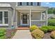 Inviting front porch with a wreath, white railing, and well-manicured landscaping at 1201 Bridle Path, Marietta, GA 30068