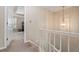 Hallway featuring decorative lighting, staircase, and entrance to an adjacent room at 1201 Bridle Path, Marietta, GA 30068