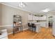 Open-concept kitchen featuring white cabinets, hardwood flooring, and an eat-in breakfast bar at 1201 Bridle Path, Marietta, GA 30068