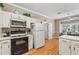 Bright kitchen showcasing a black oven, refrigerator, and ample counter space with views of the open living space at 1201 Bridle Path, Marietta, GA 30068