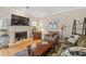 Cozy living room with fireplace, large TV, wood floors, and plenty of seating at 1201 Bridle Path, Marietta, GA 30068