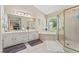 Main bathroom featuring tile flooring, dual sinks, soaking tub and enclosed shower at 1201 Bridle Path, Marietta, GA 30068