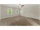 Spacious bedroom featuring neutral carpet, bright windows, and a ceiling fan for added comfort at 1502 Lake Koinonia Dr, Woodstock, GA 30189