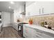 Modern kitchen boasts white cabinets, granite countertops, stainless steel appliances and tiled backsplash at 2300 Harbersham Marina Rd # 102, Cumming, GA 30041