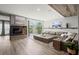 Open-concept living room with hardwood floors, modern fireplace, and sliding glass doors to a balcony at 2300 Harbersham Marina Rd # 102, Cumming, GA 30041