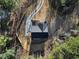 Aerial view of a home with dark roof and surrounded by lush trees with a long driveway at 3785 Pilgrim Mill Rd, Cumming, GA 30041