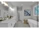 A well-lit bathroom featuring a double sink vanity, soaking tub, and luxurious finishes at 3785 Pilgrim Mill Rd, Cumming, GA 30041