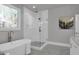 Stylish bathroom featuring a tub, glass shower, elegant fixtures, and marble tile flooring at 3785 Pilgrim Mill Rd, Cumming, GA 30041