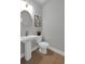 Modern powder room with pedestal sink, gold fixtures, framed abstract art, and hardwood floors at 3785 Pilgrim Mill Rd, Cumming, GA 30041