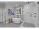 Bright bathroom featuring a soaking tub, glass shower, stylish fixtures, and marble flooring at 3785 Pilgrim Mill Rd, Cumming, GA 30041