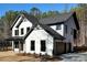 Beautiful, new two-story home with white siding, black trim, and a two-car garage with attractive landscaping at 3785 Pilgrim Mill Rd, Cumming, GA 30041
