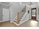 Hallway with hardwood floors, staircase with black iron spindles, and modern light fixture at 3785 Pilgrim Mill Rd, Cumming, GA 30041
