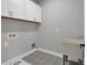 Bright laundry room features stylish patterned tile floors and white cabinetry with brushed gold hardware at 3785 Pilgrim Mill Rd, Cumming, GA 30041