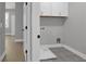 The laundry area offers ample storage with white cabinets, complementing the patterned flooring and modern design at 3785 Pilgrim Mill Rd, Cumming, GA 30041