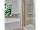 Well-lit bathroom featuring a shower and a separate soaking tub underneath a large window at 4965 Whiteoak Se Walk # 19, Smyrna, GA 30080
