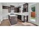 Well-lit kitchen with stainless steel appliances, island, dark cabinets, and a door to the backyard at 4965 Whiteoak Se Walk # 19, Smyrna, GA 30080